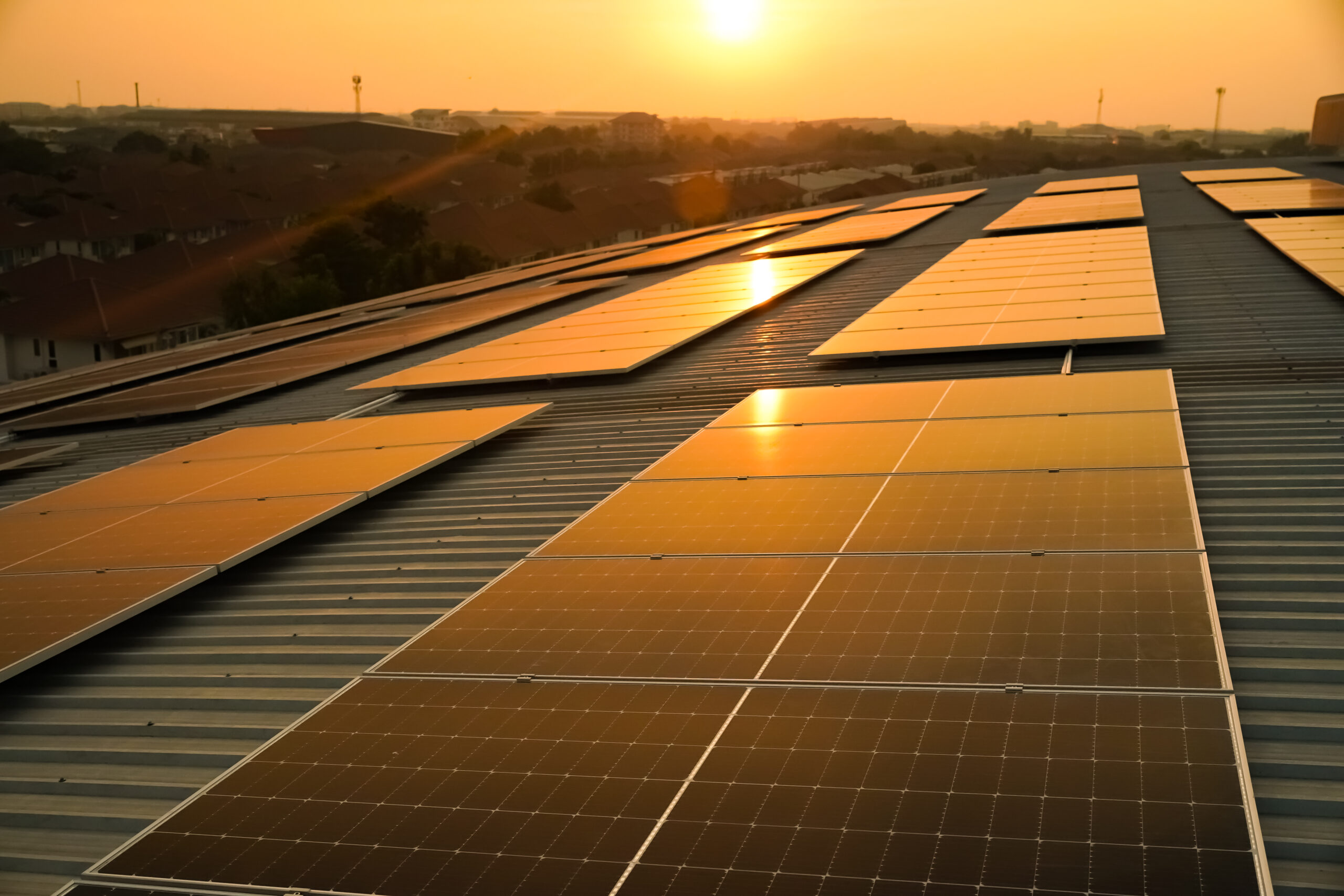 Solar panels on the meadow, sun light reflacted on solar panel on rooftop. Green energy concept